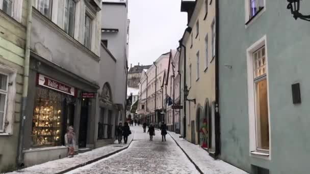 Tallinn, Estonya, bir binanın yanındaki sokakta yürüyen bir adam. — Stok video