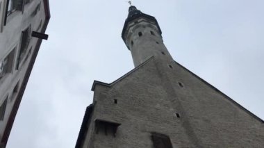 Tallinn, Estonya, bir binanın yanında saati olan büyük tuğla bir kule.