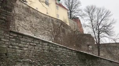 Tallinn, Estonya, tuğla duvarın yanında duvar yazısı olan taş bir bina.