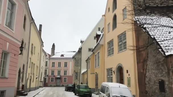 Tallinn, Észtország, egy keskeny városi utca, egy épület oldalán parkoló autókkal — Stock videók