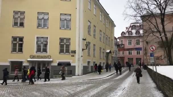 Tallinn, Estonya, 18 Şubat 2017: Bir binanın yanındaki sokakta yürüyen bir grup insan — Stok video