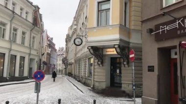 Tallinn, Estonya, bir binanın önündeki caddede yürüyen bir adam.