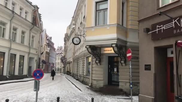 Tallinn, Estonsko, osoba kráčející po ulici před budovou — Stock video
