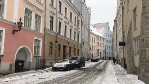 Tallinn, Észtország, egy keskeny városi utca, egy épület oldalán parkoló autókkal — Stock videók