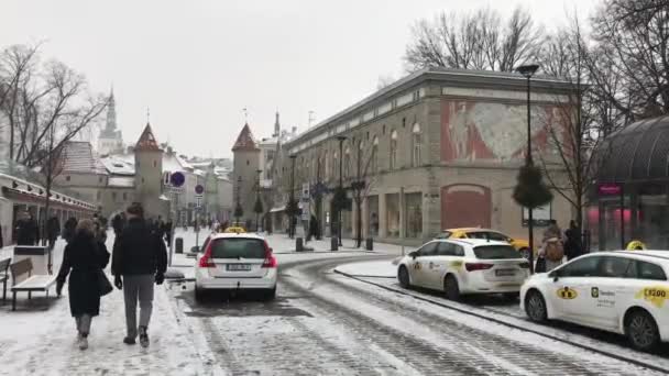 Таллінн, Естонія, 18 лютого 2017 року: група людей, які йдуть по вулиці поруч з машиною. — стокове відео