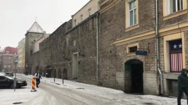 Tallinn, Estonya, bir binanın önündeki caddede yürüyen bir adam.