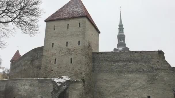 Tallinn, Estland, Een stenen kerk met een klokkentoren voor een bakstenen gebouw — Stockvideo