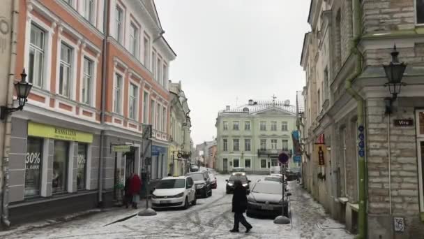 Tallin, Estonia, 18 de febrero de 2017: Una persona caminando por una calle frente a un edificio — Vídeo de stock