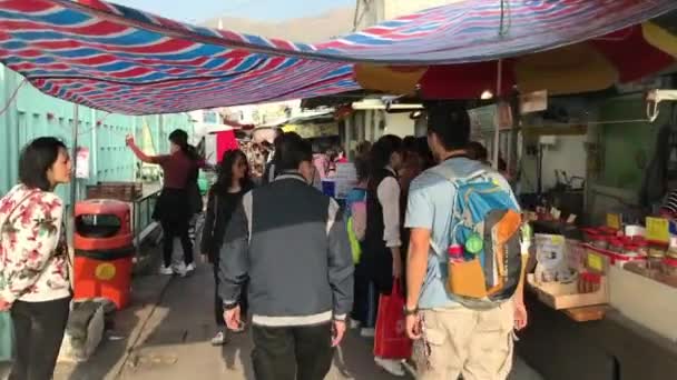 Hong Kong, China, 20 november 2016: Een groep mensen die voor een winkel staan — Stockvideo