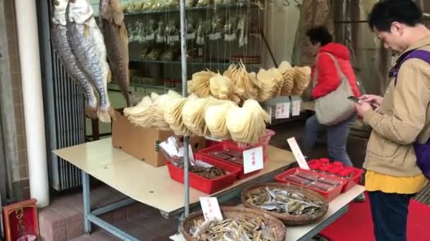 Hong Kong, China, 20 de noviembre de 2016: Una persona de pie frente a una tienda — Vídeo de stock