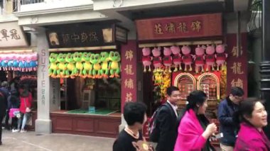 Hong Kong, Çin, 20 Kasım 2016: Bir mağazanın önünde yürüyen bir grup insan