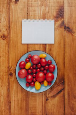 Ahşap arka plan üzerinde taze olgun domates tabak