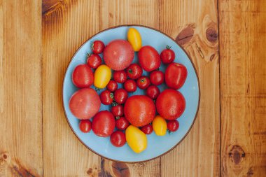 Ahşap arka plan üzerinde taze olgun domates tabak