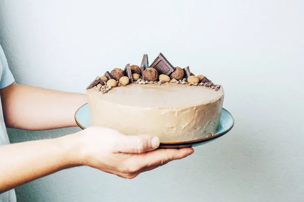 Chocolade Taart Mannelijke Handen Een Blauw Bord Zoet Geschenk Verjaardag — Stockfoto