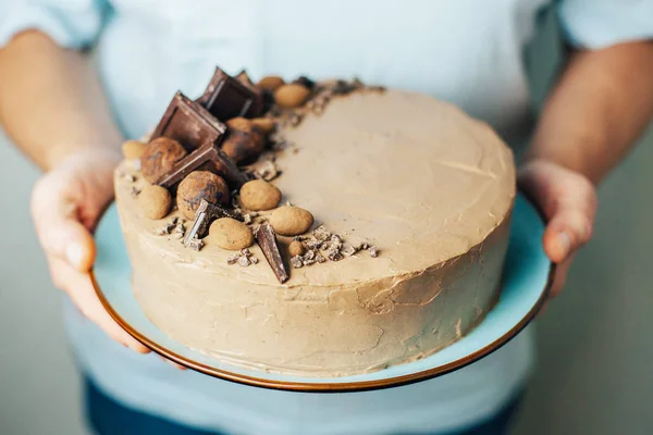 Chocolade Taart Mannelijke Handen Een Blauw Bord Zoet Geschenk Verjaardag — Stockfoto