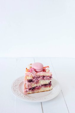 Pembe kek parçası. Dekorasyon tatlılar, macarons, şekerleme, beyaz çikolata. Tatlı Doğum günü hediyesi. Kız için.