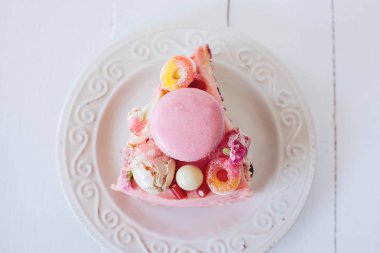 Pembe kek parçası. Dekorasyon tatlılar, macarons, şekerleme, beyaz çikolata. Tatlı Doğum günü hediyesi. Kız için.
