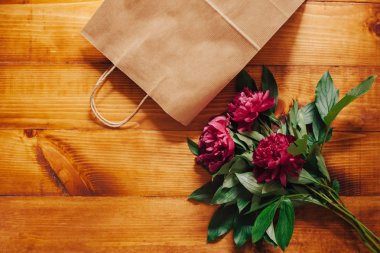 Pembe peonies ahşap bir masa üzerinde bir kağıt torba tarafından