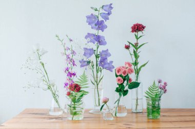 Parfüm örnekleri ve masaya çiçek güzel kompozisyonu. Şişeler çiçeklenir. Kır çiçekleri. Yaz buket.