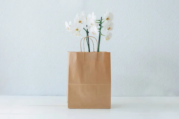 Orquídeas Una Bolsa Papel Orquídeas Blancas Bolsa Papel Mesa Blanca —  Fotos de Stock