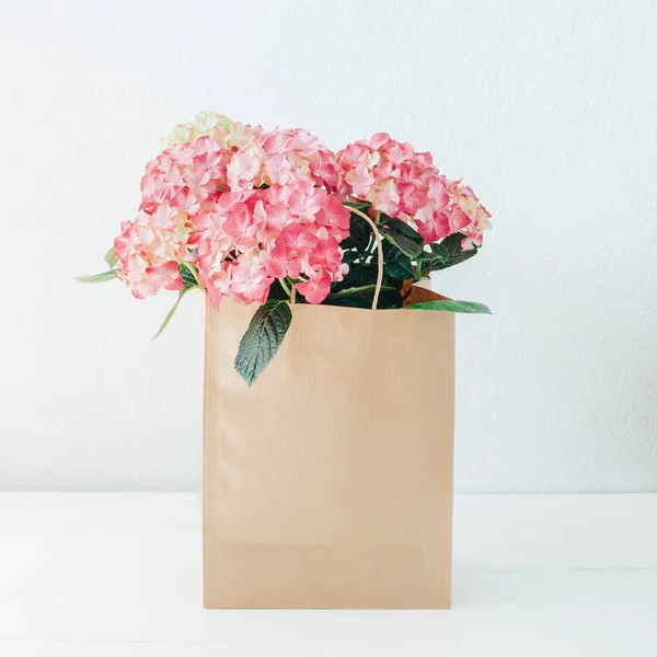 Pink hydrangea flowers in a paper bag