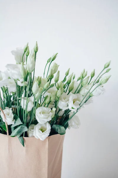 Bouquet of white eustom. Flowers close-up. Petals. White petals. Delicate. Wedding flowers. Flower delivery. Eco-package. Flowers in a paper bag. Eco-packaging. Flowers in the box.