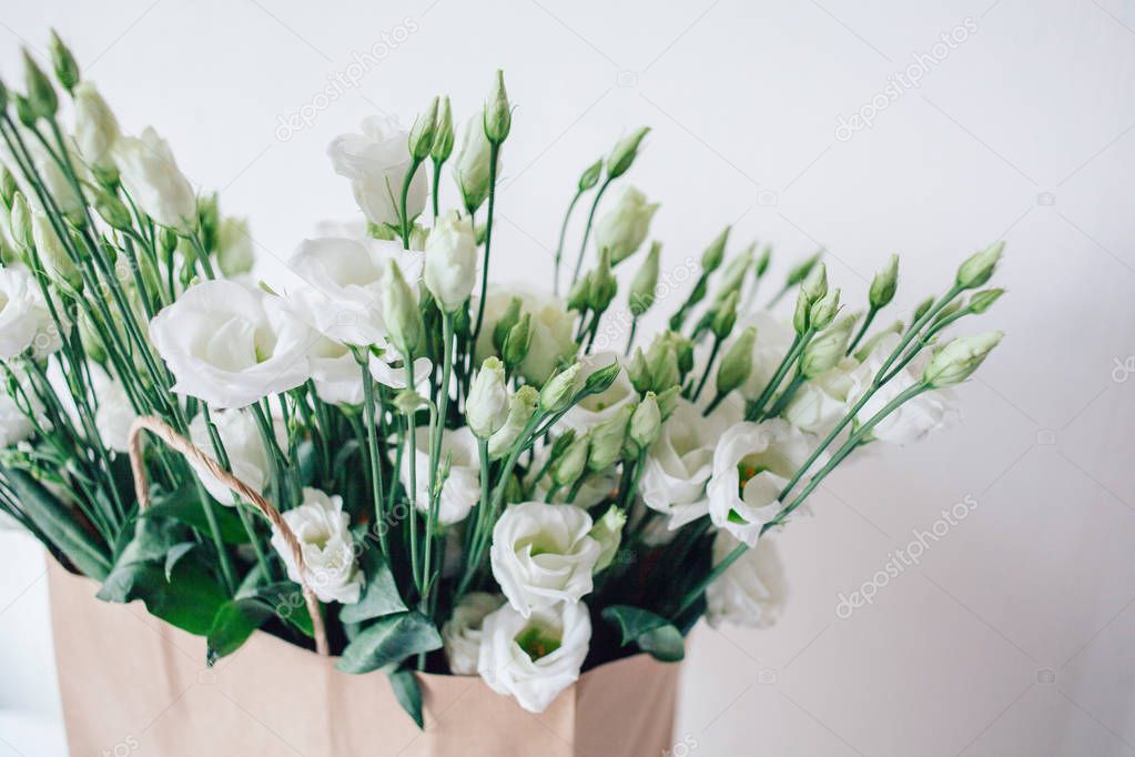 Bouquet of white eustom. Flowers close-up. Petals. White petals. Delicate. Wedding flowers. Flower delivery. Eco-package. Flowers in a paper bag. Eco-packaging. Flowers in the box.