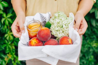 Kızın elinde Şeftalilerin sepeti.