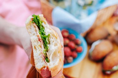 Fast food ve diyet. Piknik sandviç holding eller