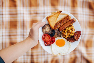 Sonbahar piknik göl yakınındaki. Geleneksel İngiliz yemekleri. İngiliz kahvaltısı elinde plaka üzerinde