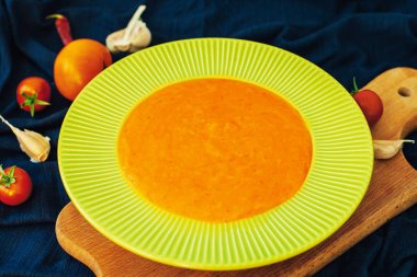 Balkabağı çorbası püresi ile baharat ahşap bir masa üzerinde. Sonbahar menüsünde. Yeşil plaka. Akşam yemeği. Sağlıklı vejetaryen yemek. Sıcak yemek.