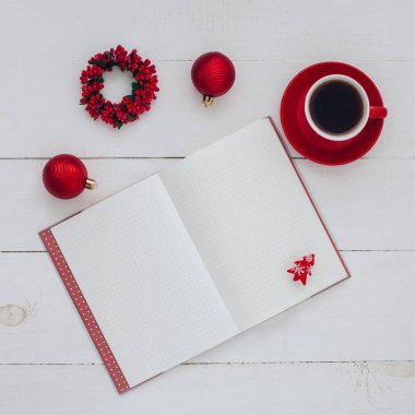 Kırmızı kahve Kupası, kırmızı baubles açılan not defteri ile ahşap tablo