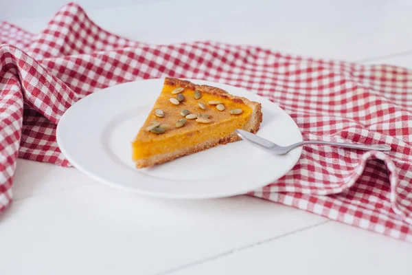 Balkabağı turta kaşık ve peçete ile beyaz tabakta tohumları ile