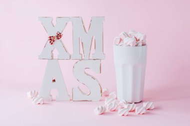 fincan kakao marshmallows pembe bir arka plan üzerinde xmas ahşap harflerle ile