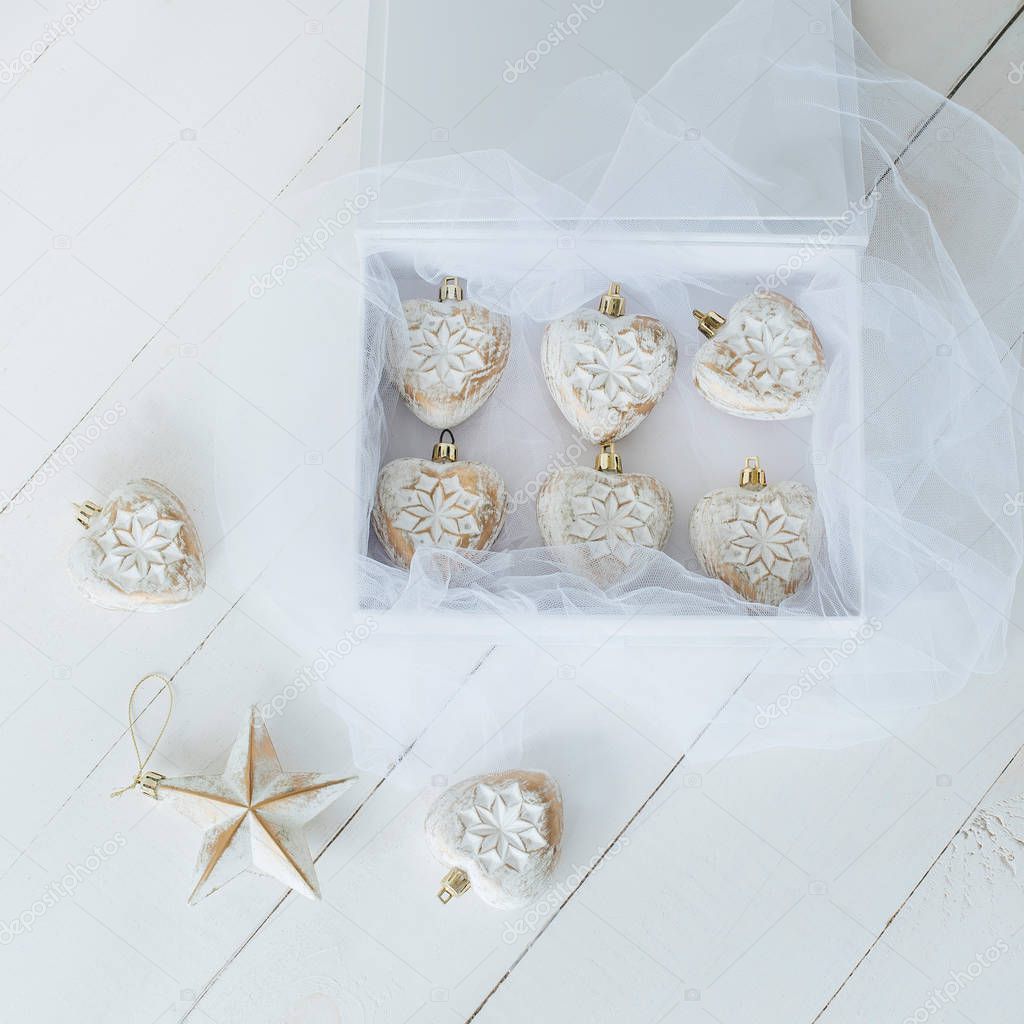 box of vintage christmas baubles on white wooden floor