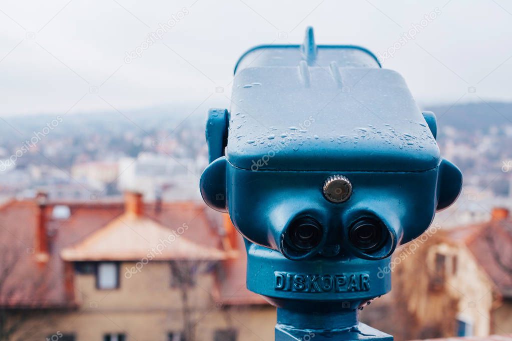 Binoculars on observation deck with city view