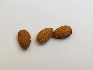 Beyaz arka planda izole edilmiş üç badem fıstığının yakın çekimi