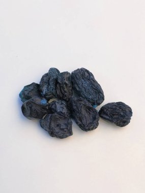 Beyaz arka planda izole edilmiş kuru üzümlü kuru üzüm meyvesi yakın plan. Beyaz üzerine izole edilmiş mavi kuru üzüm yığını.