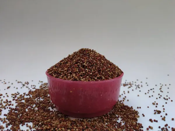 健康食品でグルテンを含まない 指雑穀 とも呼ばれる 白地に隔離されたピンク色のプラスチックボウルの中のラギ — ストック写真