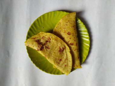 Beyaz Arkaplanda izole edilmiş bir tabakta Geleneksel Sarı Renk Dal Obbattu veya Holige Grubu