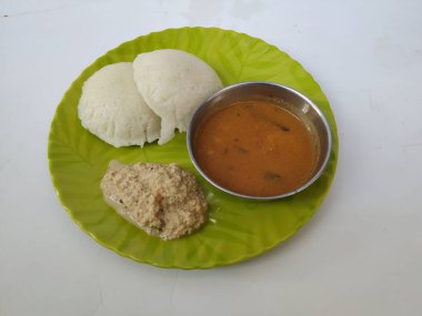 Hint vejetaryen pirinç keki, idli ya da aylak olarak bilinen kahvaltı, sambar ve Chatney ile birlikte beyaz bir arka planda izole edilmiş yeşil bir tabakta servis edilir. Lezzetli Güney Hindistan yemekleri