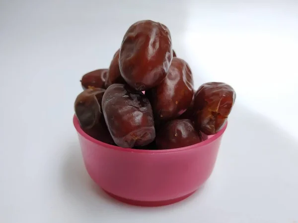 在白色背景下隔离的塑料粉盒中 用褐色 彩色水果包裹生鲜干枣 — 图库照片