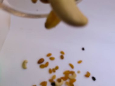 Raisin, Kishmish, Cashew ve Bamond gibi kuru meyvelerden oluşan bir grup şeffaf bir bardağı doldurdu ve izole edilmiş beyaz arka plana dağıttı.