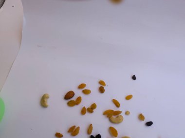 Raisin, Kishmish, Cashew ve Bamond gibi kuru meyvelerden oluşan bir grup şeffaf bir bardağı doldurdu ve izole edilmiş beyaz arka plana dağıttı.