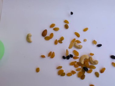 Raisin, Kishmish, Cashew ve Bamond gibi kuru meyvelerden oluşan bir grup şeffaf bir bardağı doldurdu ve izole edilmiş beyaz arka plana dağıttı.