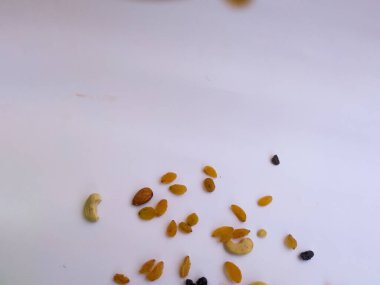 Raisin, Kishmish, Cashew ve Bamond gibi kuru meyvelerden oluşan bir grup şeffaf bir bardağı doldurdu ve izole edilmiş beyaz arka plana dağıttı.