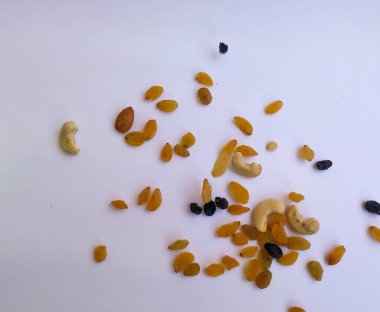 Raisin, Kishmish, Cashew ve Bamond gibi kuru meyvelerden oluşan bir grup şeffaf bir bardağı doldurdu ve izole edilmiş beyaz arka plana dağıttı.