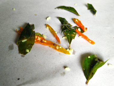 Dilimlenmiş Köri Yaprakları ve Yeşil Biber, izole edilmiş beyaz arka planda ayrılan bir limonlu pilavda kullanılır.