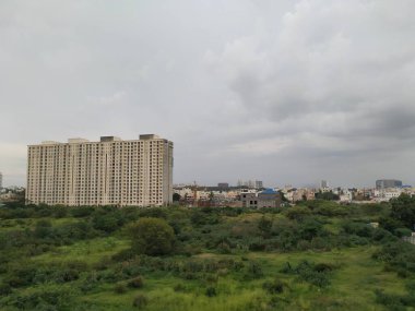 Bangalore, Karnataka / Hindistan-28 Haziran 2020: Hebbal yakınlarında yağmurlu bulutlu arka plan veya akşam manzaralı Hindistan Sarı Renkli Çok Katlı Apartman