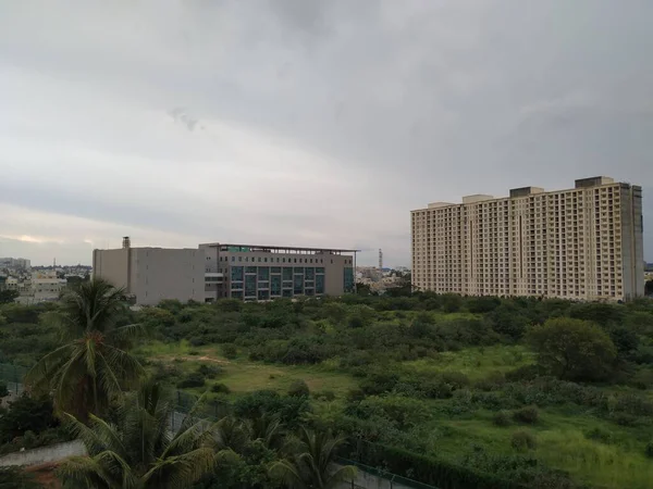 バンガロール カルナータカ州 2020年6月28日 ヘブル近郊の雨の多い雲の背景または夕景のある都市におけるインドの黄色のマルチフロアアパートメントの閉鎖 — ストック写真